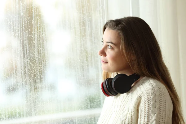 Pensive adolescent regardant par une fenêtre dans un jour de pluie — Photo