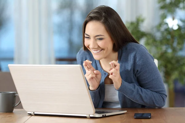 Chica feliz cruzando los dedos comprobando el contenido en línea —  Fotos de Stock