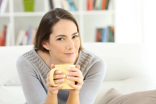 Dona de casa olhando para a câmera segurando uma xícara de café — Fotografia de Stock