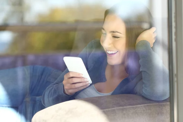 Vista esterna di una donna che usa un telefono a casa — Foto Stock