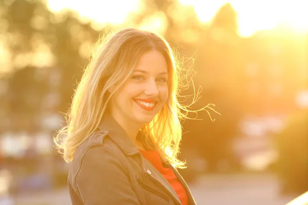 Retrato de uma mulher feliz sorrindo ao pôr do sol — Fotografia de Stock