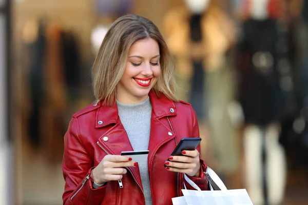 Comprador pagando en línea con una tarjeta en un centro comercial — Foto de Stock