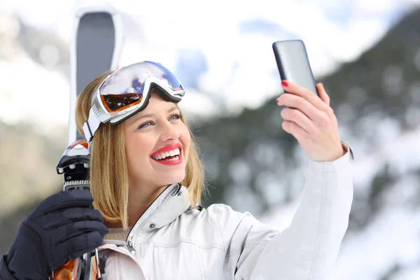 Лыжник делает селфи со смартфоном — стоковое фото