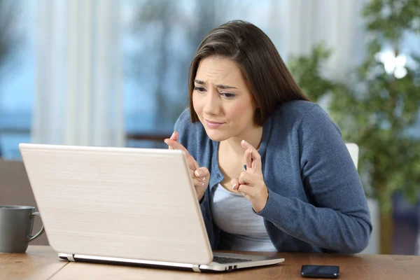 Mujer cruzando dedos comprobando contenido en línea —  Fotos de Stock