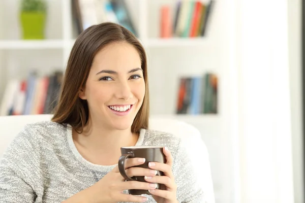 Mujer sosteniendo una taza de café posando en casa —  Fotos de Stock