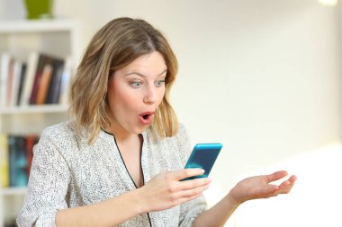 Sürpriz kız mavi telefondaki çevrimiçi içerik izlerken