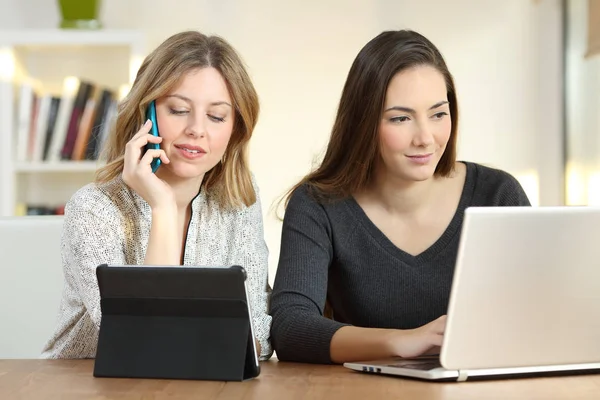 Two girls searching content using multiple devices