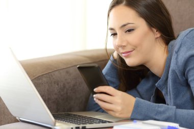 Kız bir kanepede Smartphone ileti denetimi