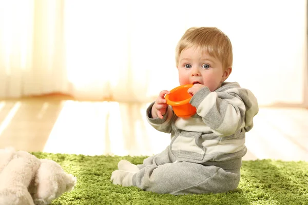 Bebê distraído mordendo um brinquedo — Fotografia de Stock