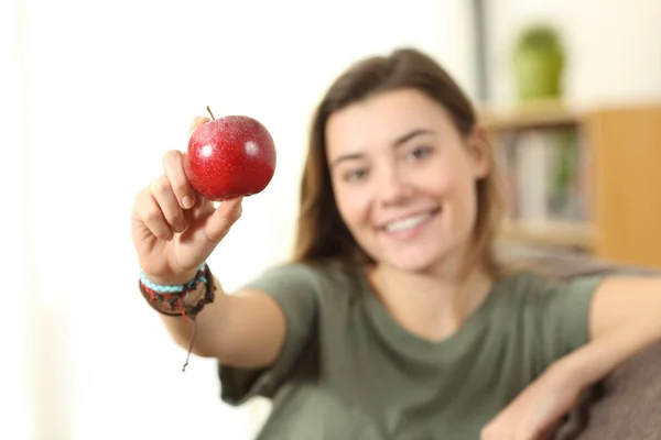 Adolescente mostrando una manzana en casa — Foto de Stock