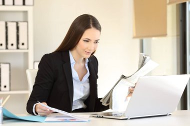 Ofis çalışanı bir gazete ile çevrimiçi içerik karşılaştırma