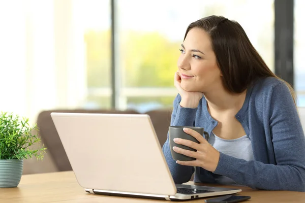 Woman dreaming with a laptop at home — Stock Photo, Image