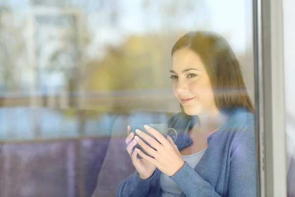 Mujer mirando hacia adelante a través de una ventana — Foto de Stock