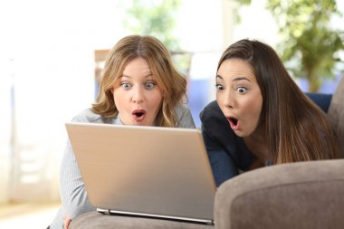 Şaşırmış arkadaşlar bir kanepede satır içerik izlerken