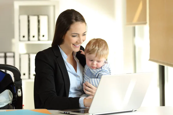 Mom working with her baby son at office — Stock Photo, Image