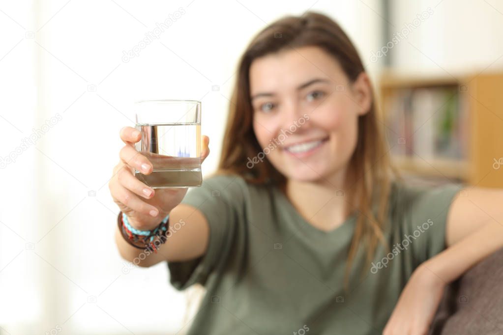 Healthy teen showing a glass of water