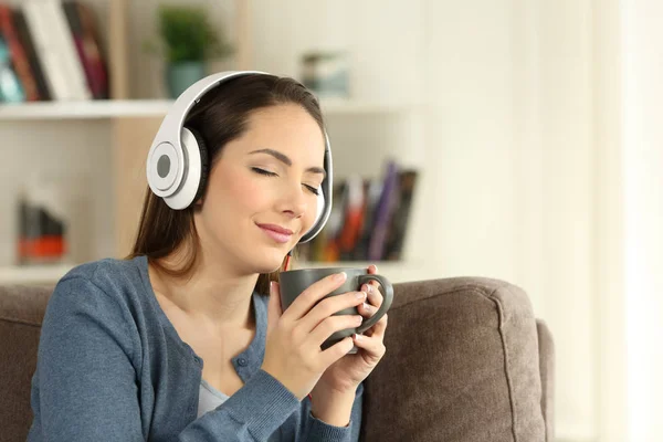 Женщина расслабляется, пьет и слушает музыку — стоковое фото