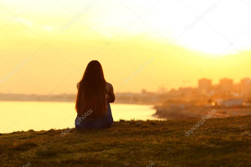 Woman seeing a sunset on the city