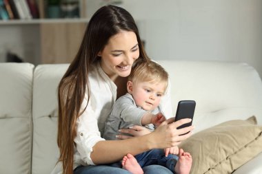 Anne ve bebek bir akıllı telefon ile oynamak