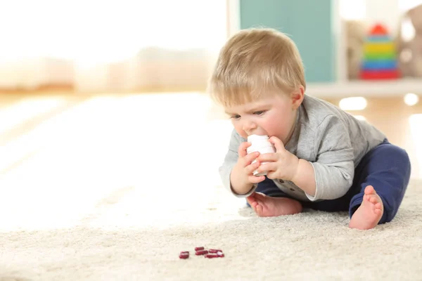 Bambino in pericolo giocando con una bottiglia di medicinali — Foto Stock