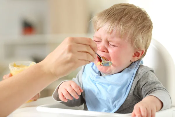 Mãe alimentando seu filho que está chorando — Fotografia de Stock