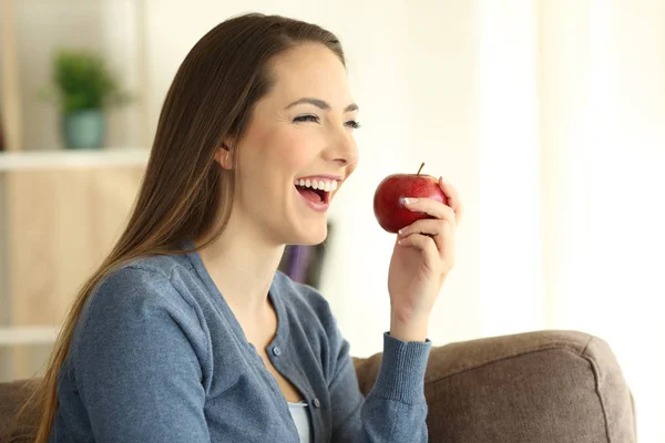 Mujer feliz comiendo una manzana mirando hacia otro lado — Foto de Stock