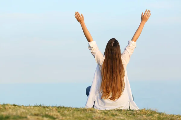 Zufriedene Frau, die die Arme in den Himmel reckt — Stockfoto