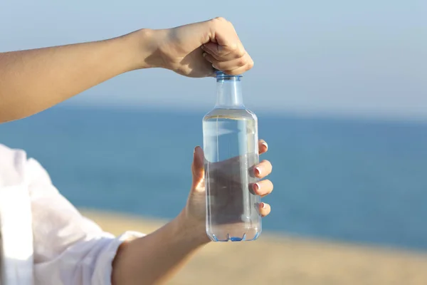 Mulher mãos abrindo uma garrafa de água ao ar livre — Fotografia de Stock
