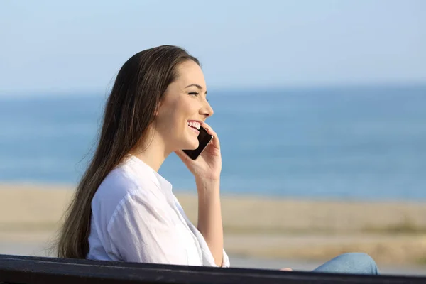 Mosolygó hölgy beszél telefonon a strandon — Stock Fotó