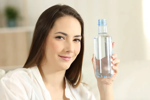 Chica relajada mostrando una botella de agua genérica —  Fotos de Stock