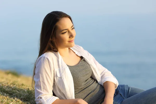 Woman contemplating on the grass on a beach — Stock Photo, Image