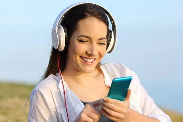 Kadınla çimenlerin üzerinde açık havada müzik dinlemek — Stok fotoğraf