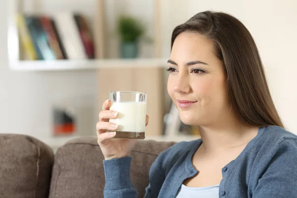 Entspannte Frau mit einem Glas Milch zu Hause — Stockfoto