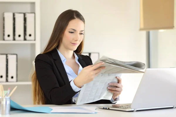 Femme d'affaires sérieuse lisant un journal au bureau — Photo