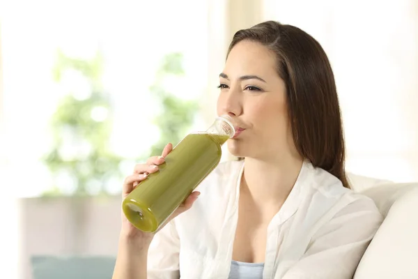 Женщина пьет овощной сок из бутылки — стоковое фото