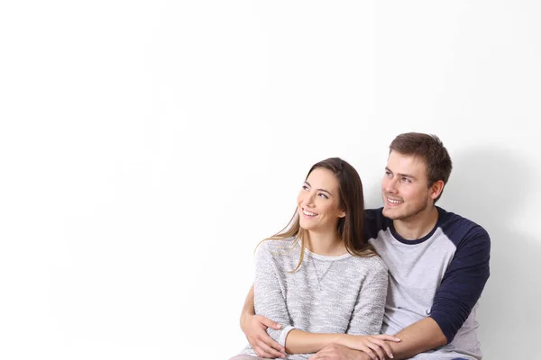 Casal olhando para o lado em uma parede branca — Fotografia de Stock