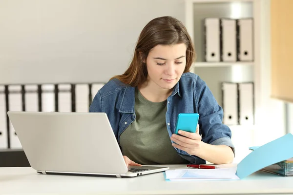 Intern checking phone message at office — Stock Photo, Image