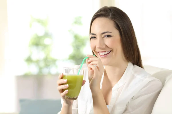 Woman drinking a vegetable juice looking at camera — Stock Photo, Image