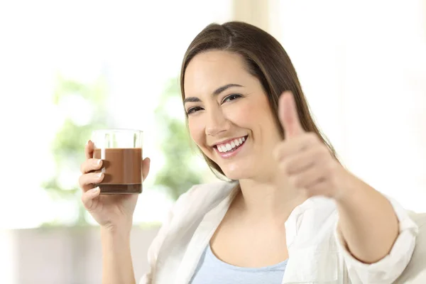 Femme tenant une boisson de cacao regardant la caméra — Photo