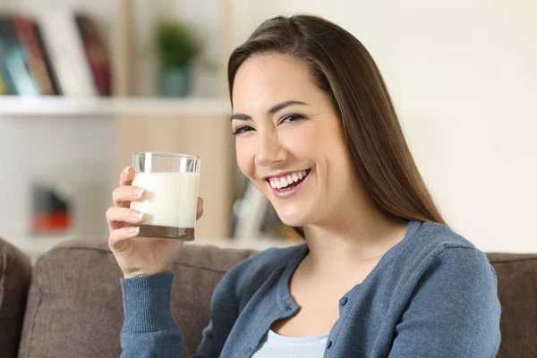 Kvinna som håller ett glas mjölk tittar på kameran — Stockfoto