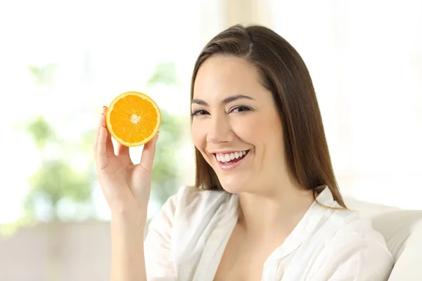 Mujer mostrando media naranja en casa — Foto de Stock