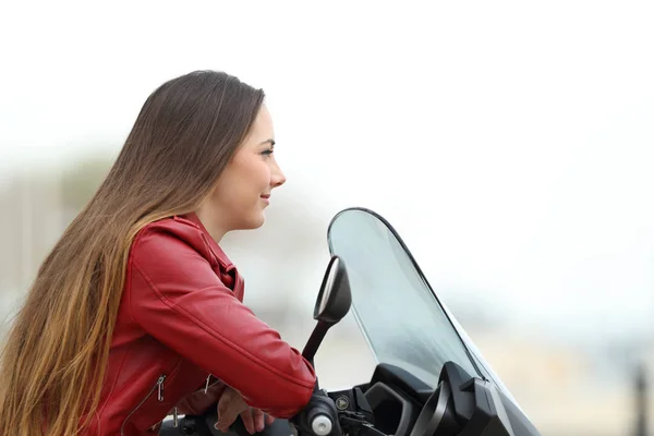 Мотоциклист смотрит на мотоцикл — стоковое фото