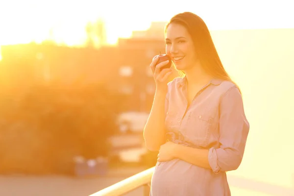 Donna incinta che tiene una mela e ti guarda — Foto Stock