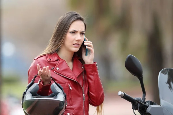 Motociclista enojado llamando al seguro por teléfono — Foto de Stock