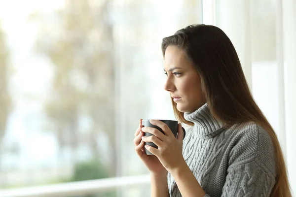 Mujer enojada mirando por una ventana — Foto de Stock