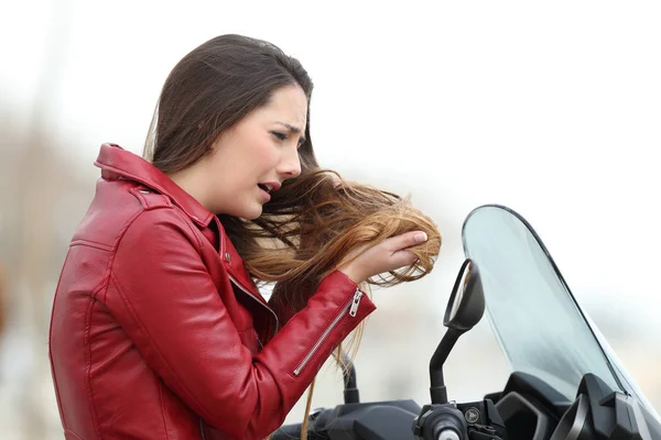 Biker woman complaining about tangled hair — Stock Photo, Image