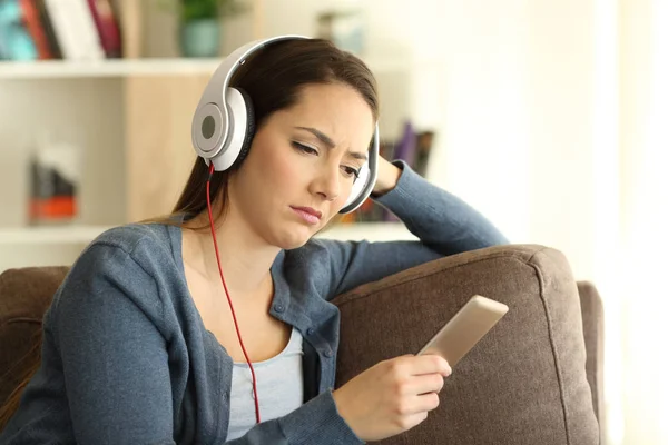 Sad girl wearing headphones listening to music — Stock Photo, Image