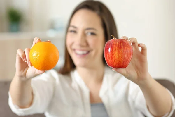 Mujer mostrando dos frutas diferentes — Foto de Stock