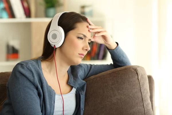 Menina preocupada ouvindo música em casa — Fotografia de Stock