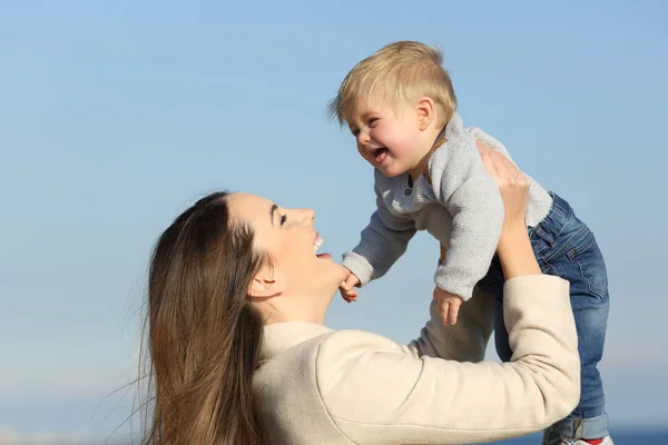 Glada mor spelar höja hennes baby son — Stockfoto